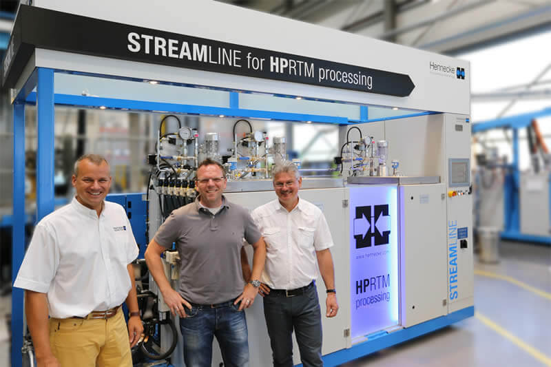 Cumulative know-how of fiber composite components production (from left to right): Jens Winiarz (Head of Sales Composites & Advanced Applications), Jens Geuer (Product Manager Lightweight Technologies), and Jürgen Wirth (Manager Application & Development Technology) in front of the new 3-Component STREAMLINE in the Hennecke TECHCENTER